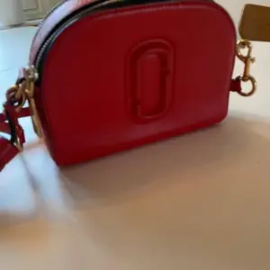 Röd Marc Jacobs väska ”äkta”. Köparen betalar frakten. 