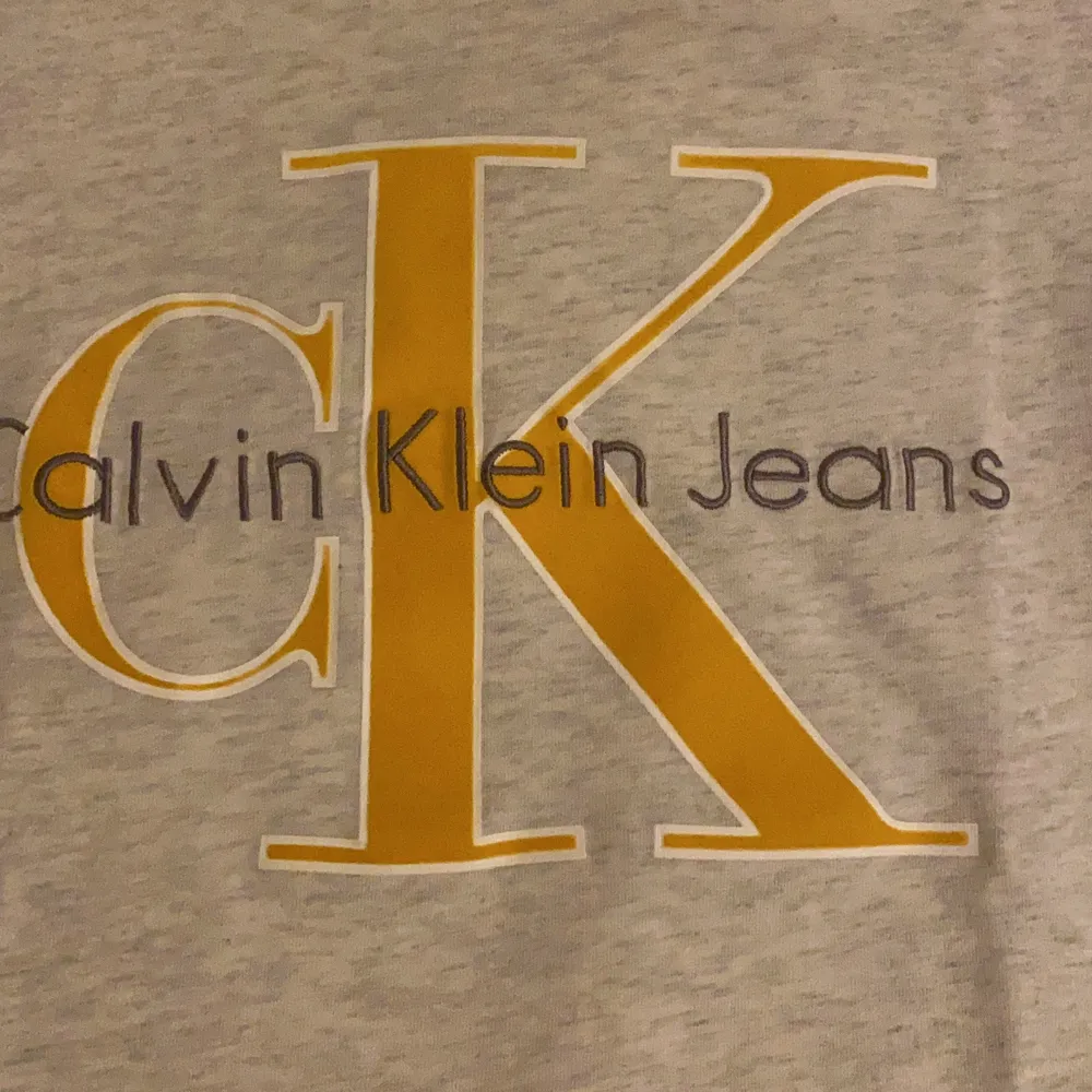 Calvin Klein t-shirt. Typ grå vit med gult, vit, gråt tryck . T-shirts.