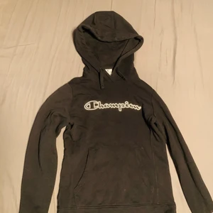 Champion hoddie - En svart champion luvtröja med vit märke, storlek S/Small, passar även XS. Använd ett fåtal gånger😊
