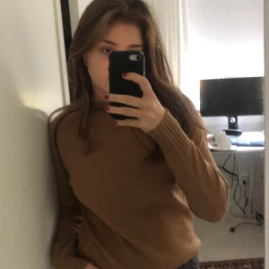 Snygg tröja i hasselnötsfärg med marinblå ränder vid axlarna.😀 - En stickad tröja i en ljusbrun färg