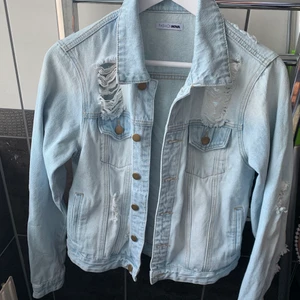 Jeansjacka med slitningar  - Säljer denna super snygga jeans jackan med slitningar köpt på Fashion Nova. aldrig använd! Ny pris 600kr.