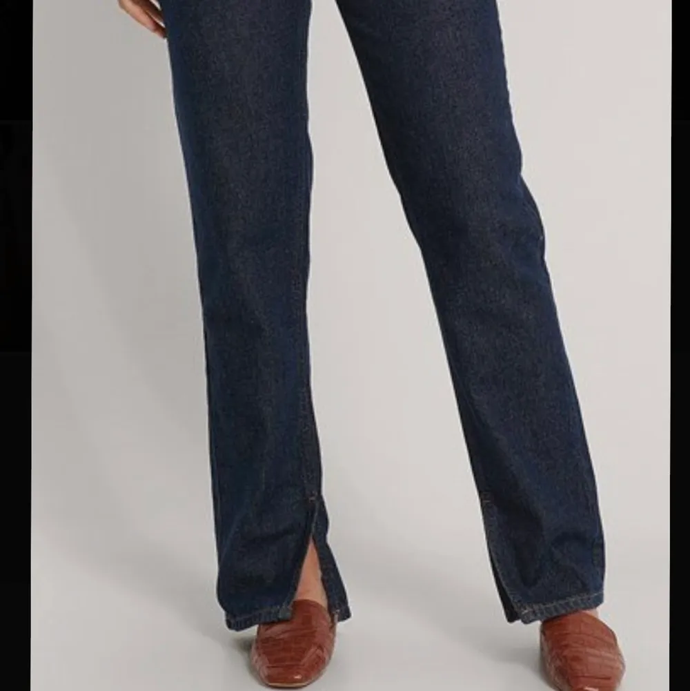 Mörkblåa jeans från NA-KD, knappt använda. Högmidjade och en slits nere på benen. Köpare står för frakt:). Jeans & Byxor.