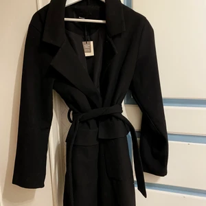 Kappa - En svart mysig kappa i svart! Helt oanvänd från bikbok i storlek M, Kappan har två fickor på framsidan och ett snöre man kan knyta runt midjan! orginalpriset 750kr 