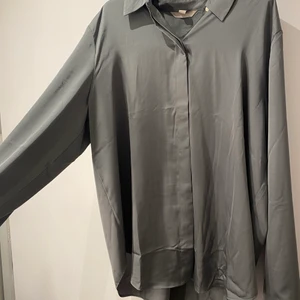 satin skjorta - Satin skjorta i en grå/grön färg, storlek M men sitter fint oversized på mig, när den är öppen och har ett linne under.  använder inte längre så säljer pågrund av det💓 pris kan diskuteras