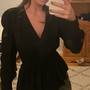 Svart långärmad blus h&m - Svart långärmad blus från hm. Omlott och resor i midjan och volang nertill. Ballongärmar. Jättefin festtopp🌸