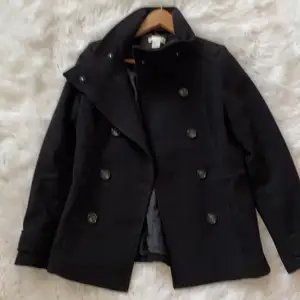 En stilig svart kappa som är köpt från H&M. Kappan är i storlek 38 och passar dem med storlek 36-40. Den är knappt använd. 