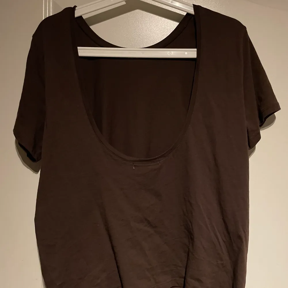 Aldrig använd Mörkbrun T-shirt med djup urringning i ryggen, från nakd. Köparen står själv för frakten . T-shirts.