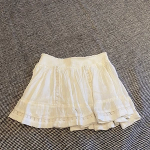 Vit kjol med detaljer som matchar med det mesta - Har en liten glugg i en sömn som lätt går att fixa, Resår i midjan så sitter väldigt bekvämt. Storlek L men passar S-L