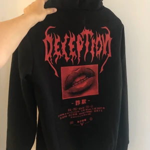 Hoodie med tryck - En svart hoodie med rött tryck på baksidan. Aldrig använd och prislappen är kvar. Annars är det en super cool hoodie som bara inte kommit till användning är hemma. Storlek XS men passar även mig som är S och dig som är XS eller XXS :D, 100kr eller högsta bud