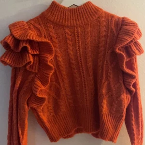 Orange stickad tröja - Fin orange stickad tröja med volanger!