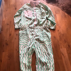 One piece vit med gröna mönster 34 - One piece vit med gröna mönster och 3 fickor liknar en skjorta. Öppet under armarna.