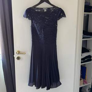 Fin mörkblå klänning. Perfekt för t.ex. skolavslutning. Köpt för 2/3 år sedan men endast använd 1 gång. Det finns en insydd bygel i klänningen men inget man märker av. Knäppning med dragkedja i sidan.