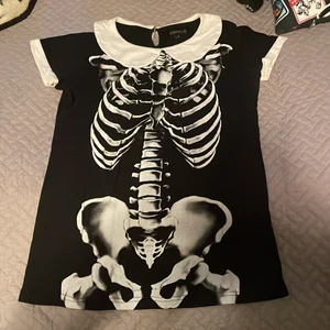 Gothic topp  - Tröja/blus från Gothicana by EMP i storlek medium 🖤 Kroppsnära fit. Tyvärr har den en liten fläck på kragen (se andra bilden), därav det låga priset. Frakten går på 62, eller 66 om man vill ha spårbart. 
