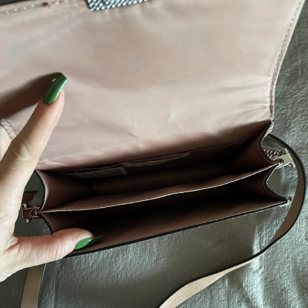 Ny oanvänd  taupe färg fina detaljer, mindre väska . Accessoarer.