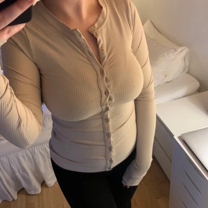 Nicki Studios topp strl XS - Topp från Nicki Studios i en snygg beige färg med knappar. Långa ärmar och en modell som kramar om din kropp. Storlek XS. Använd flitigt men i fint skick. 