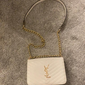 Ysl väska  - Ysl väska vit med guldiga detaljer. 450 kr, röd inuti ni får betala frakten själv