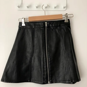 Svart A-linjekjol i läderimitation storlek 34 - A-linjeformig kjol i läderimitation i storlek 34. Sparsamt använd. Felfritt skick. 