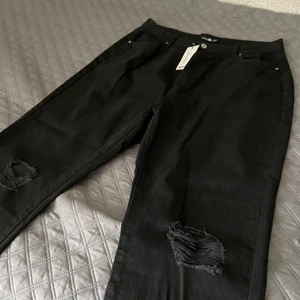 Slitna mom jeans med hög midja från Boohoo - Svarta mom jeans för de curvigare kropparna. Hög midja och lite baggy nertill. Inte nöjd med hur de satt på mig och returen kostade mer än vad själva plagget kostade😃😃 kanske någon med plus size storlek som tror att dessa passar, tveka inte att höra av dig! Storlek 44 men kan passa om man har strl 46 