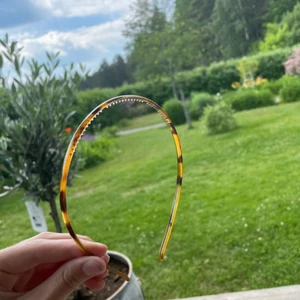 Transperant Brown tunnt Hårband  - Kostar 35kr + frakt. Det är ett smalt hårband med taggar/piggar. Den har färgen Transperant Brown.  