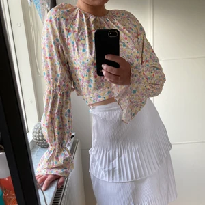 Somrig blommig blus från NAKD. Storlek S - Fin sommarblus med öppen rygg. Använt endast en gång.