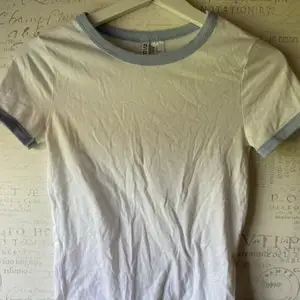 Vit t-shirt från HM med ljusblå kant i storlek xs. Knappt använd, fint skick. 