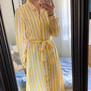 Randig klänning - Gul och vit randig klänning. Fint skick, endast använd en gång. Storlek M men passar även mindre. Passar perfekt till sommaren vid olika tillställningar.