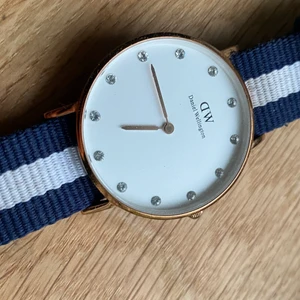 Daniel Wellington klocka - Fin klocka från Daniel Wellington i roseguld, med ett vitt och blått band till.