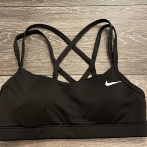 Nike sport-BH - Detta är en jättefin svart sport-BH från Nike i storlek xs. Det är ilägg i den som gärna enkelt flytta på dig men inte svårt att rätta till. Köparen står för frakten. Rök och djurfritt hem! OBS står ej för postens slarv 