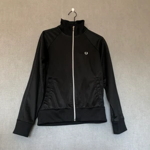 Hel svart Fred Perry zip - • Ziptröja som passar till iprincip allt, alltid. Härlig istället för jacka vid varmare väder. Klassisk & tidlös! • Storlek: 34/36, kroppsnära modell • 50% bomull & 50% polyester • Relativt välanvänd, se alla bilder! • +Frakt: 57kr spårbart 