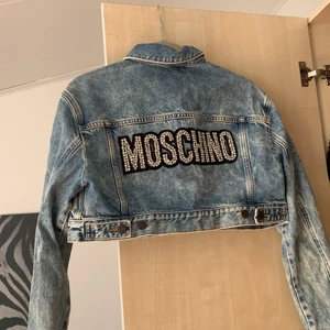 Jeansjacka Moschino  - Kortare modell i jeans med text bak på ryggen, från märker Moschino. Aldrig använd 