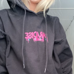 Svarthoodie med tryck - Jätte snygg, behaglig, cool hoodie från boohoo. Använt så många gånger men är fortfarande ett så otroligt bra skick. Helt sjukt vilket bra material den har!! På trycket står det Paradise 