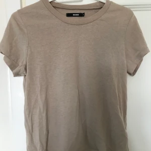 Beige T-shirt  - En skön beige Basic T-shirt från bikbok. 