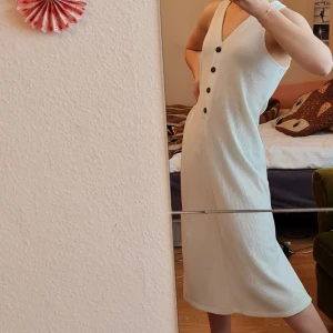 Klänning - Vit ribbad klänning med knappar. Från MANGO i storlek S.