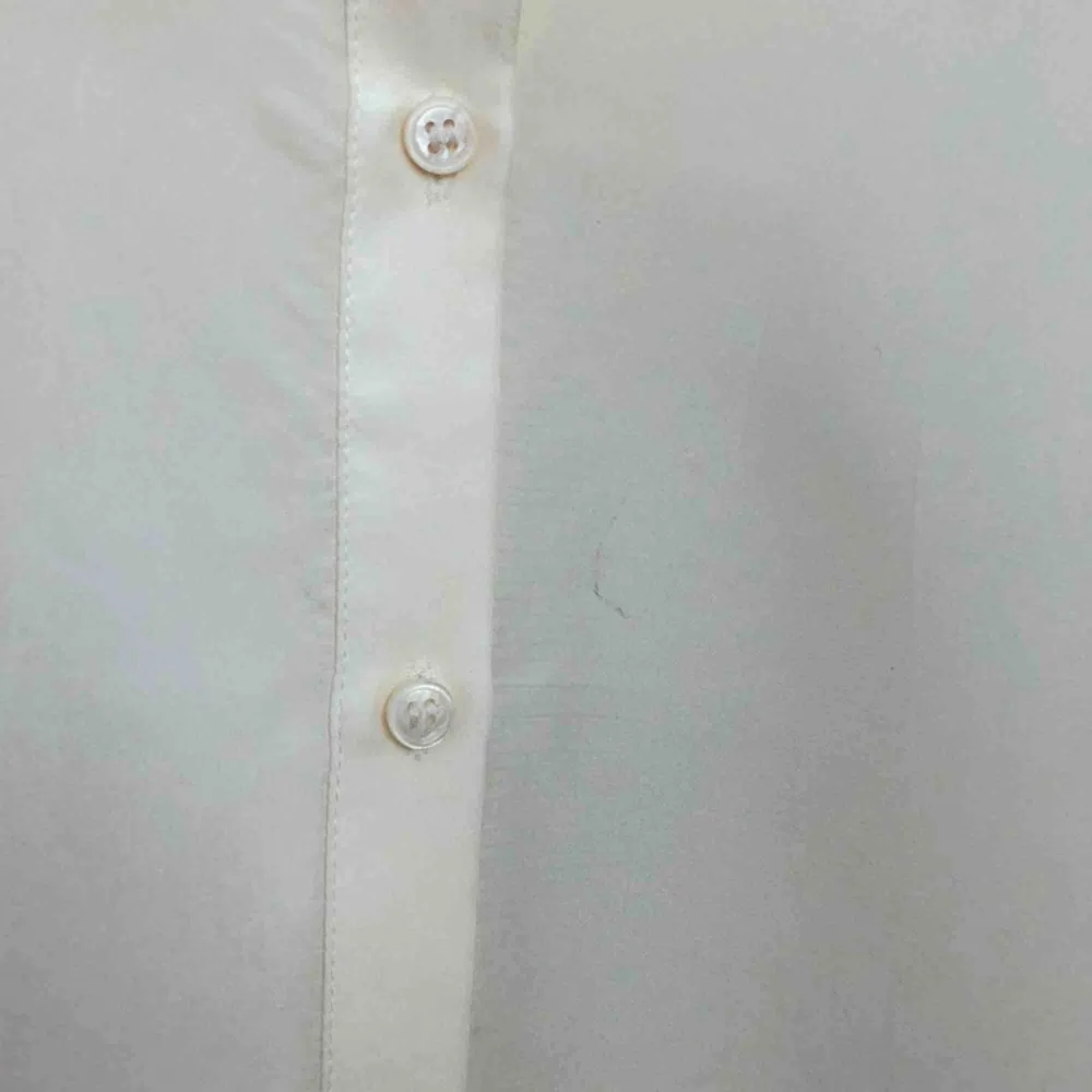 Off white sidenblus från H&M. Oversize i modellen, passar riktigt bra uppknäppt med linne under. Finns en liten fläck på framsidan som knappt syns! . Blusar.