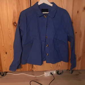 Sommarjacka Monki  - Blå somrig jacka från Monki med brun/svart melerade knappar och två fickor. Sparsamt använd. Storlek M men passar även S (jag är själv strl S).Lågt pris pga möts ej upp utan skickar på post och köpare står för frakt! :)