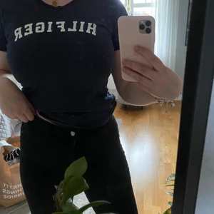 Marinblå Tommy Hilfiger T-shirt  - Jag säljer denna marinblåa Tommy Hilfiger t-shirten som jag använt fåtal gånger som ser ut som ny. Den kommer från ett rökfritt hem och tvättas alltid innan den skickas och har du fler frågor är de bara att höra av dig.