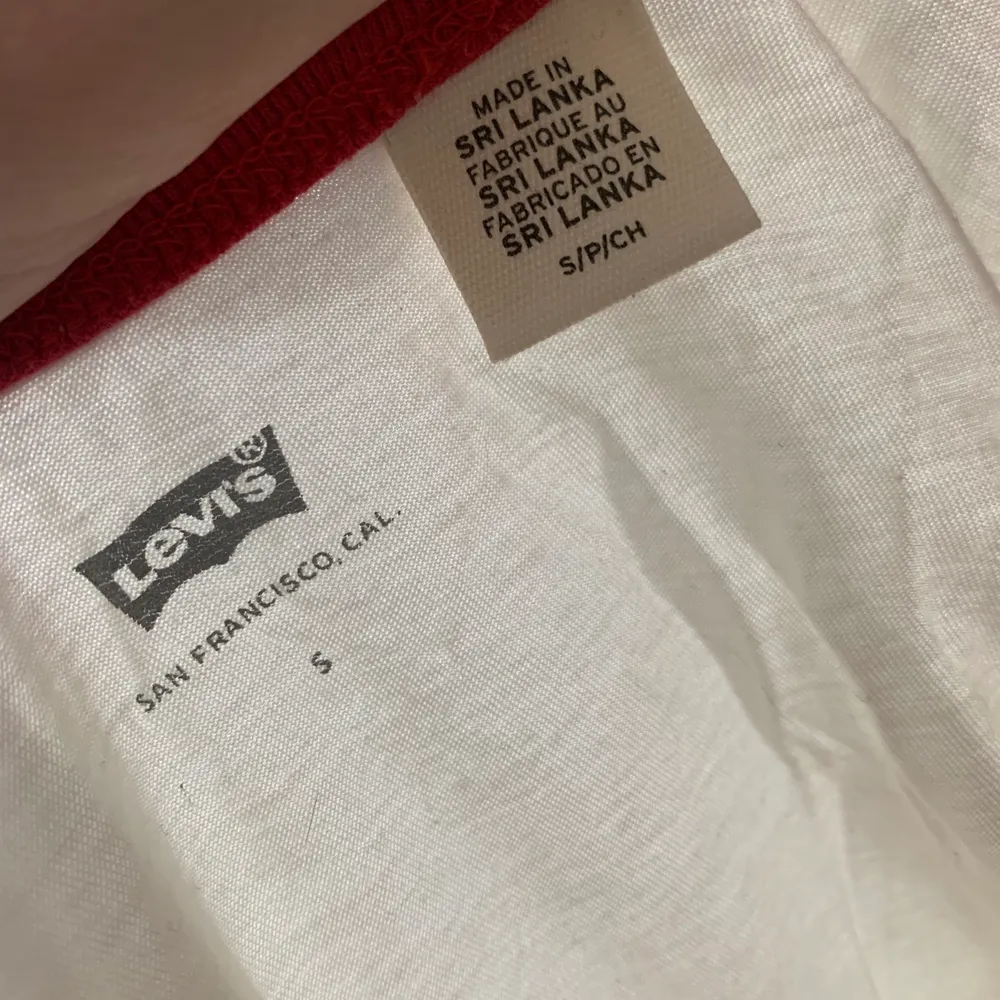 En vit Levis t-shirt med röda detaljer, är i bra skick. Dock lite genomskinlig. Köparen står för frakt, betalning sker via swish. T-shirts.