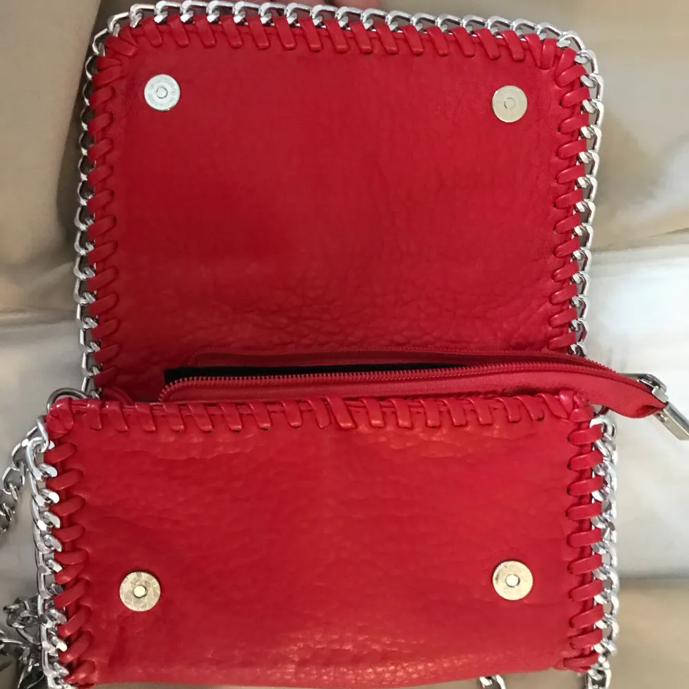 Röd Tiamo väska i minsta storleken! Köpt på scorett! Väldigt bra skick, endast använd fåtal gånger, som ny! Väldigt gullig nu till våren!. Väskor.