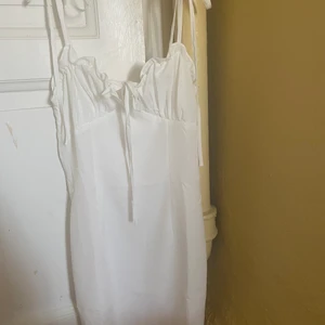 Sommrig klänning  - Aldrig använd då den är för liten för mig. Försedd med rosetter som axelband och vid bysten. Har även en dragkedja i ryggen