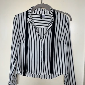 Randig Skjorta HM - En fin randig CROPPED skjorta från HM med snöre vid halsen. Den är storlek 34 och har en bra passform på någon som är runt 160cm. 