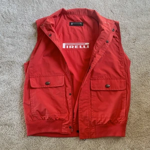 Röd Pirelli Väst - Säljer denna coola väst från racing-märket Pirelli! Storleken är 52 men skulle säga att den passar M/L! Jag på bilden är 172cm och brukar bära storlek 38/S-M❤️