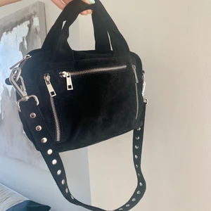 NUNOO Donna väska  - Säljer nu min väska från märket NUNOO i modellen Donna då den aldrig kommit till användning. Använd ett FÅTAL gånger och har nästan bara legat i min garderob. Väskan är i ett svart mocka liknande material med avtagbart band. Hör av dig vid frågor!❤️