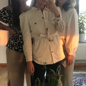 Beige skjorta med puffade axlar  - En beige skjorta i jeanstyg. Puffade axlar och knyte i midjan💗 kan användas som jacka