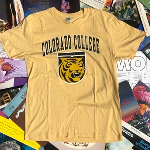 T-SHIRT!! 💿💿 - Säljer en vintage t-shirt från early 00’s. Tröjan är från Colorado University. Tröjan är i riktigt bra skick och trycket har mycket crackings men enligt mig ger det bara en najs karaktär till tröjan. Tröjan är L och funkar både för dam som herr. Skulle säga att den passar tts herr och L/Xl dam. Funkar säkert najs oversized också. Det är bara att skriva om ni har någon mer fråga, läs gärna bio innan ni skriver!! 🌎💫🌱