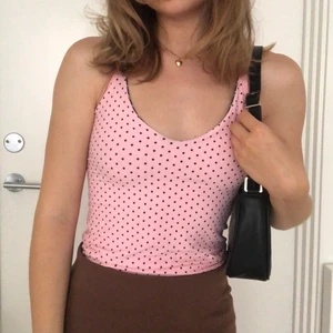 Rosa linne - Jättesöt ljusrosa halterneck linne med små bruna prickar på som går att vända ut och in, där tyget är brunt med ljusrosa ränder (se sista bild) 💗 Materialet är baddräkts likt. Storlek står ej men passa mig som är XS. 🌼 Aldrig använd, lapp sitter kvar. Köpt på Depop 🌸