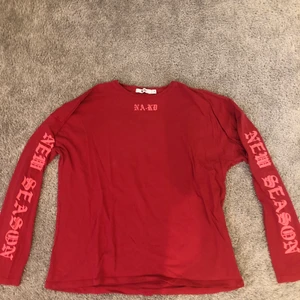Långärmad - En röd NA-KD långärmad med tryck på ärmarna, väldigt fin passar till det mesta!!