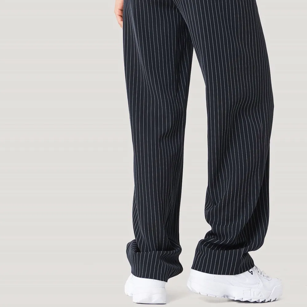 Svarta kostymbyxor med vita ränder från NA-KD. I bra skick. Nypris 550kr. Jeans & Byxor.