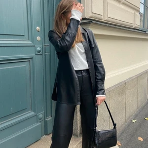 Vårjacka i skinimitation - En fin och trendig vårjacka i fake läder som är perfekt till våren och hösten. Den tillkommer även med ett bälte beroende på hur man vill styla den. Jackan har används men säljer eftersom den inte används lika flitigt längre och den är fortfarande i ett väldigt bra skick. Köparen står för frakt och pris kan diskuteras💕