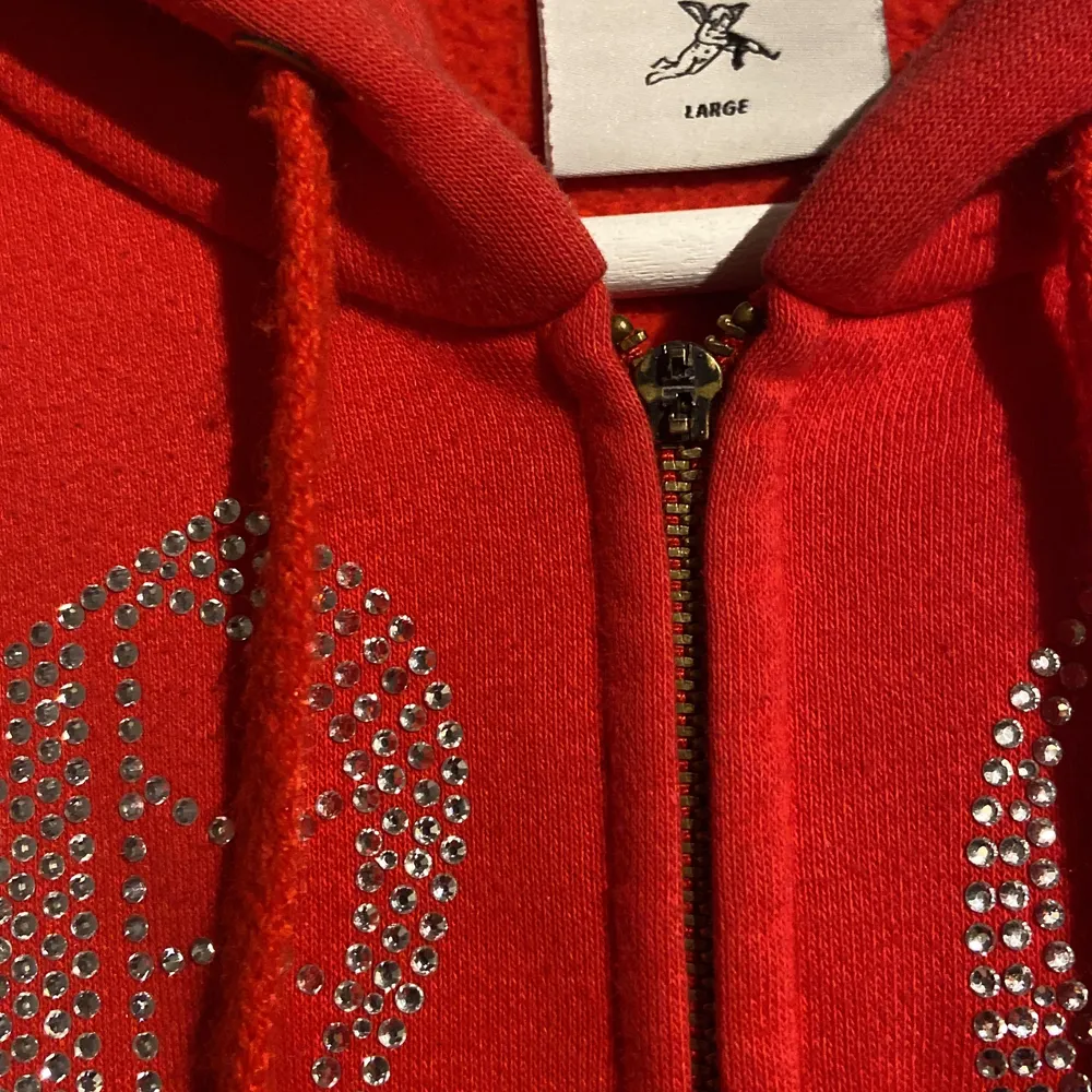 Strl L, använda men i bra skicka förutom att själva zipsaken man drar i har lossnat men lätt att fixa bara man köper en ny sån och att 1 rhinestone har lossnat. Hoodies.