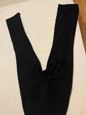 Svarta kostymbyxor från Bik Bok - Klassiska svarta kostymbyxor från Bik Bok i rak modell. Byxorna har diskreta bakfickor och är tillverkade i ett mjukt material som känns bekvämt hela dagen. Perfekta att styla med skjorta eller t-shirt för en clean look. Det saknas en knapp men det går och använda ändå!